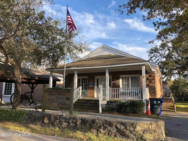 view of front of house with brick siding and a porch
