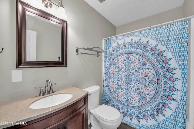 full bath with curtained shower, a textured ceiling, toilet, and vanity