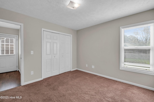 unfurnished bedroom featuring a closet, baseboards, and carpet