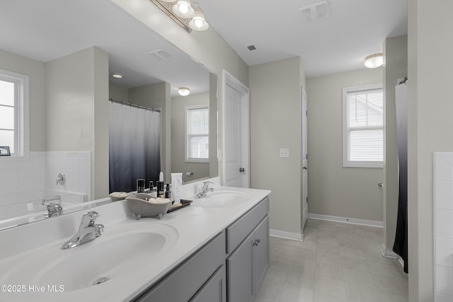 bathroom featuring double vanity and baseboards