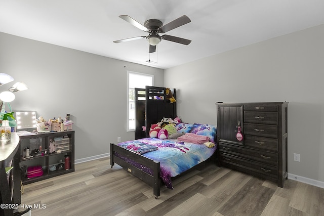 bedroom featuring light wood-type flooring, a ceiling fan, and baseboards
