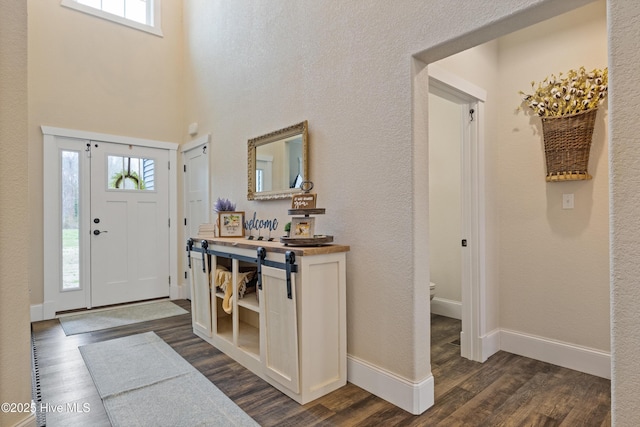 entryway with baseboards and dark wood-style floors