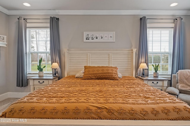 bedroom with baseboards, ornamental molding, and multiple windows