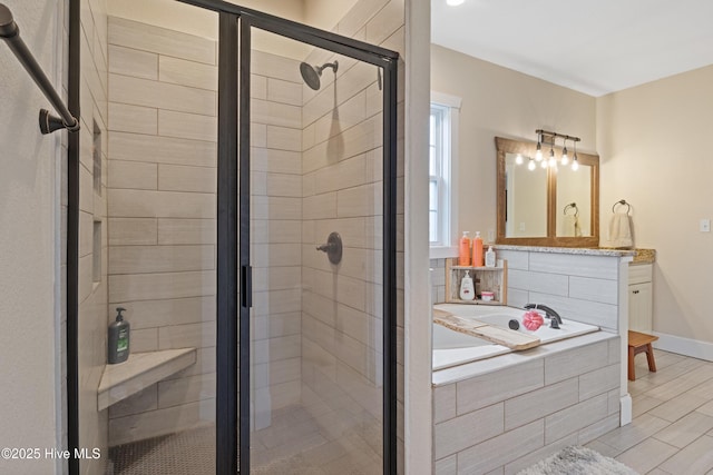 bathroom with a bath, baseboards, and a stall shower