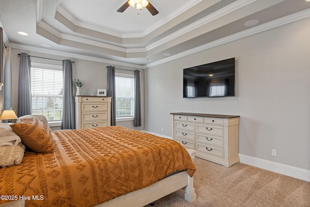 bedroom featuring ceiling fan, light carpet, a tray ceiling, baseboards, and ornamental molding