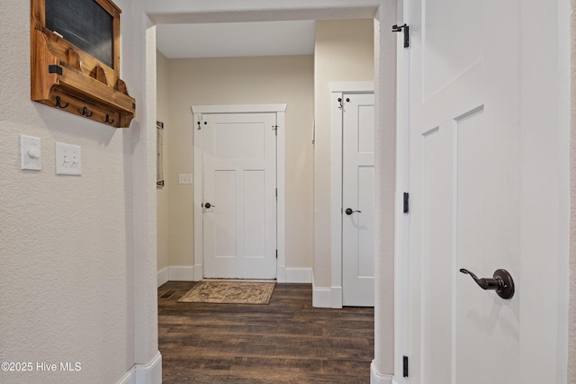 corridor with baseboards and dark wood-style flooring