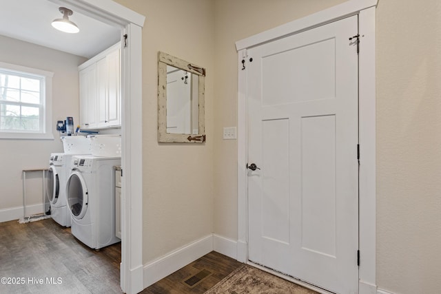 laundry room featuring washing machine and dryer, baseboards, cabinet space, and dark wood-style floors