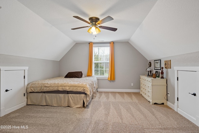 carpeted bedroom featuring vaulted ceiling, baseboards, and ceiling fan
