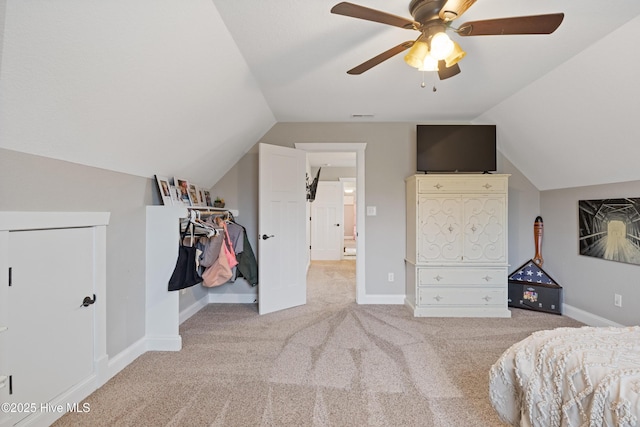 bedroom with baseboards, visible vents, light colored carpet, lofted ceiling, and a ceiling fan