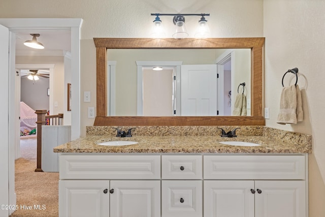 full bathroom featuring double vanity, a ceiling fan, and a sink