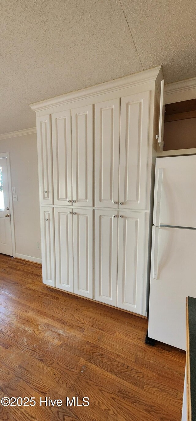 6693 NC-92, Bath, NC 27808 - room details with wood finished floors, baseboards, freestanding refrigerator, ornamental molding, and a textured ceiling