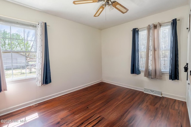 spare room featuring plenty of natural light, visible vents, and dark wood-style flooring