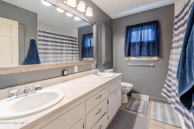 full bath featuring tile patterned flooring, double vanity, toilet, and a sink
