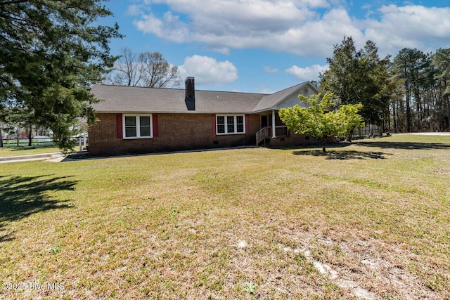 view of front of property featuring a chimney, a front lawn, crawl space, and brick siding