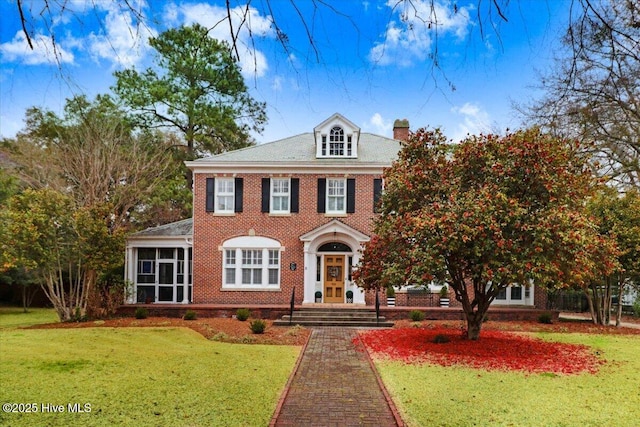 705 Park Ave, Goldsboro, NC 27530 - colonial home featuring brick siding, a chimney, and a front yard
