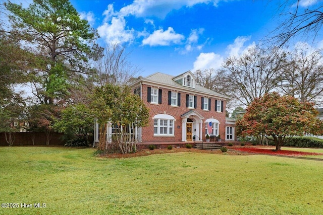 705 Park Ave, Goldsboro, NC 27530 - colonial-style house with a front yard, fence, and brick siding