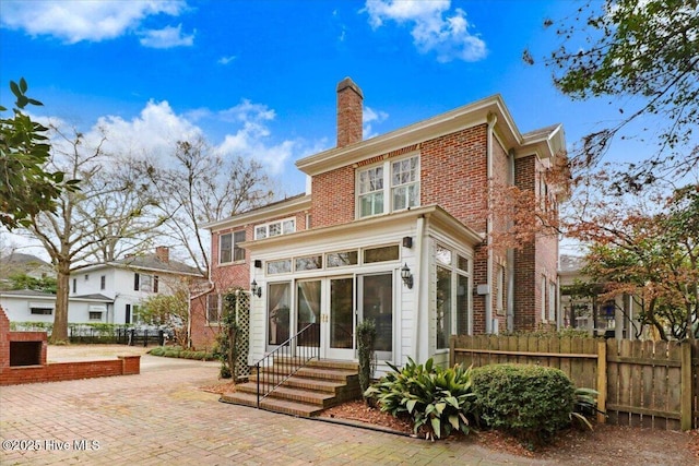705 Park Ave, Goldsboro, NC 27530 - rear view of property with entry steps, fence, a sunroom, brick siding, and a chimney