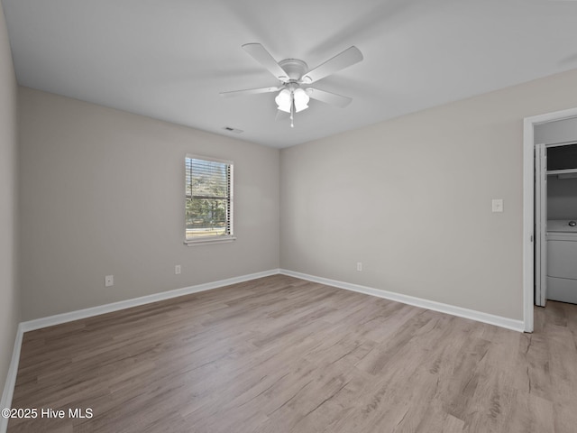 spare room featuring visible vents, baseboards, washer / clothes dryer, light wood-type flooring, and a ceiling fan