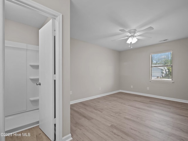 unfurnished bedroom with baseboards, a ceiling fan, wood finished floors, and visible vents