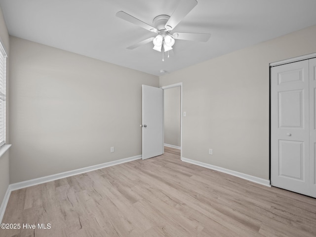 unfurnished bedroom with baseboards, ceiling fan, a closet, and light wood finished floors
