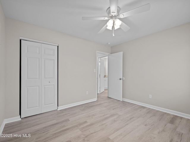 unfurnished bedroom featuring a closet, light wood finished floors, and baseboards