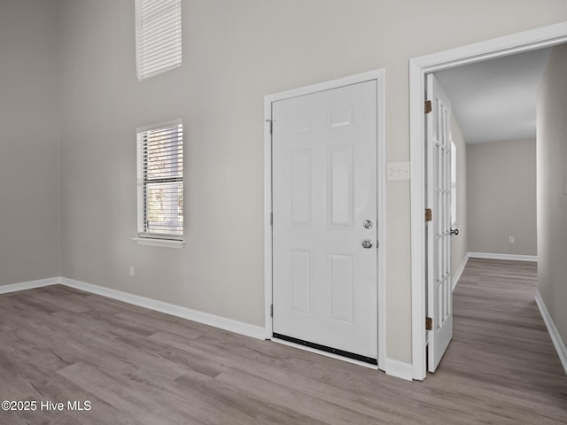 foyer with baseboards and wood finished floors