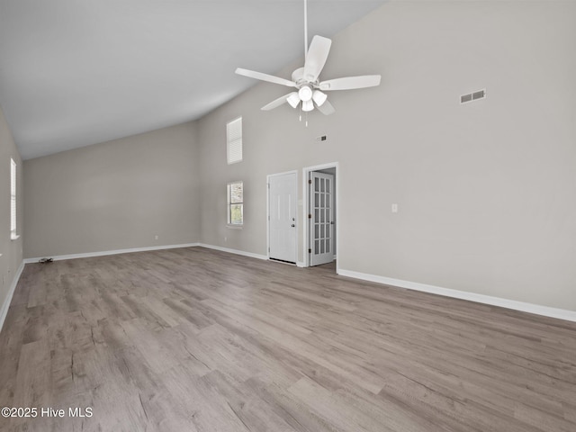 unfurnished living room featuring visible vents, wood finished floors, baseboards, ceiling fan, and high vaulted ceiling