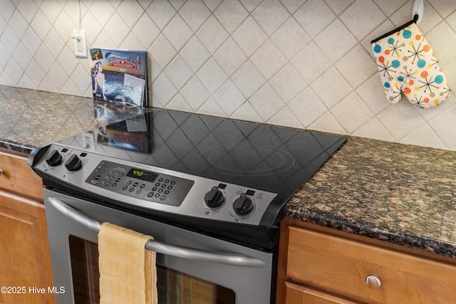 604 Fourth St S, Carolina Beach, NC 28428 - kitchen with stainless steel range with electric cooktop, backsplash, dark countertops, and brown cabinets