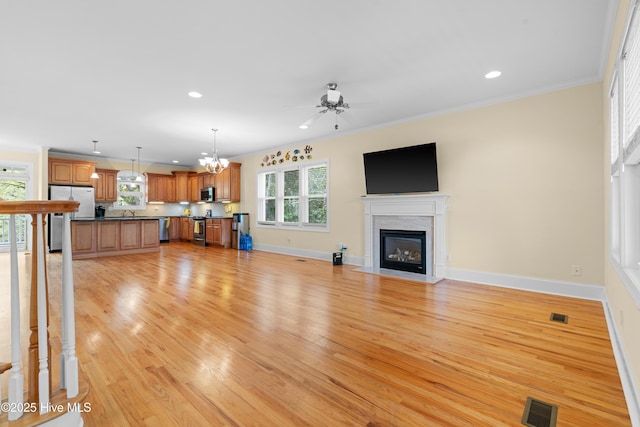 604 Fourth St S, Carolina Beach, NC 28428 - unfurnished living room with a ceiling fan, light wood-style floors, plenty of natural light, recessed lighting, and crown molding