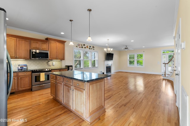 604 Fourth St S, Carolina Beach, NC 28428 - kitchen featuring stainless steel appliances, a fireplace, light wood finished floors, backsplash, and recessed lighting