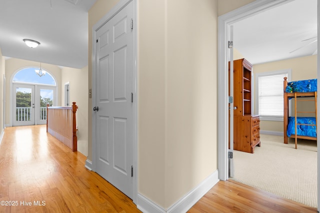 604 Fourth St S, Carolina Beach, NC 28428 - hallway with light wood finished floors, french doors, and a chandelier