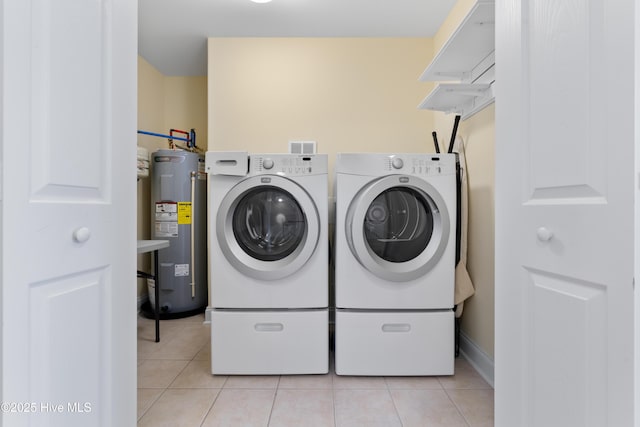 604 Fourth St S, Carolina Beach, NC 28428 - laundry room with electric water heater, washing machine and dryer, and light tile patterned floors