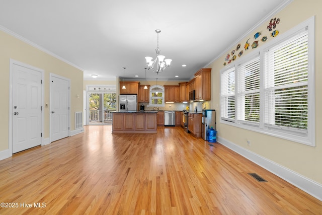 604 Fourth St S, Carolina Beach, NC 28428 - kitchen featuring stainless steel appliances, a chandelier, brown cabinets, dark countertops, and crown molding