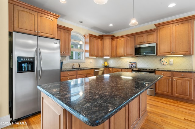 604 Fourth St S, Carolina Beach, NC 28428 - kitchen featuring appliances with stainless steel finishes, light wood-style flooring, brown cabinets, crown molding, and backsplash
