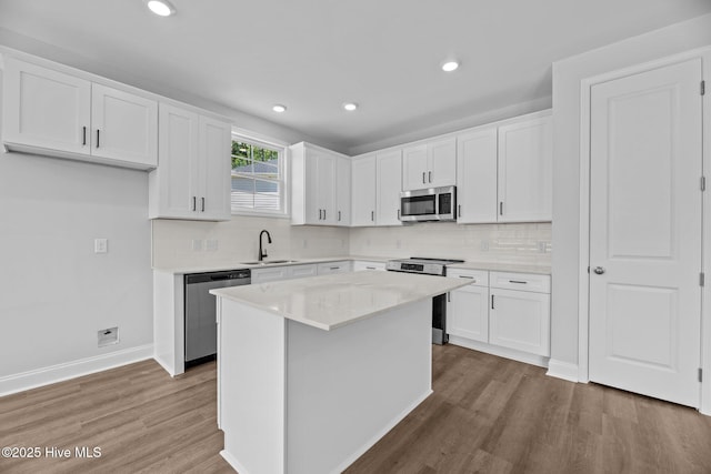1007 Tawney Trce, New Bern, NC 28562 - kitchen with appliances with stainless steel finishes, a sink, light wood-style flooring, white cabinetry, and recessed lighting