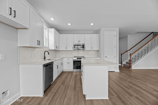 1007 Tawney Trce, New Bern, NC 28562 - kitchen featuring stainless steel appliances, baseboards, light wood-type flooring, backsplash, and a sink
