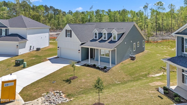 1007 Tawney Trce, New Bern, NC 28562 - view of front facade featuring board and batten siding, covered porch, concrete driveway, a shingled roof, and a front yard