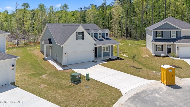 1007 Tawney Trce, New Bern, NC 28562 - traditional-style house with driveway, board and batten siding, a wooded view, a porch, and a front lawn