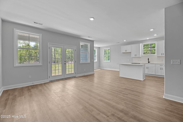 1007 Tawney Trce, New Bern, NC 28562 - unfurnished living room with baseboards, healthy amount of natural light, light wood-type flooring, recessed lighting, and a sink