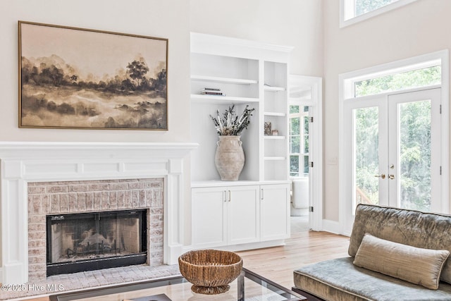 6932 Runningbrook Ter, Wilmington, NC 28411 - living area featuring a brick fireplace, light wood finished floors, french doors, and built in features