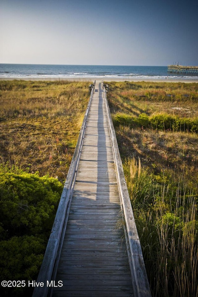 view of property's community featuring a beach view and a water view