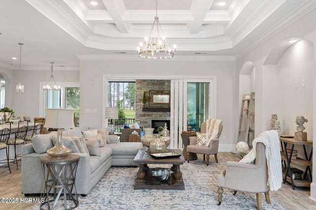 living area featuring a chandelier, arched walkways, and crown molding