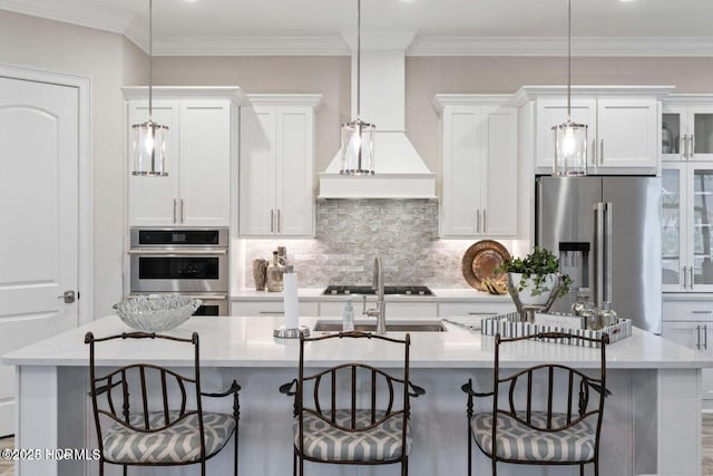 kitchen featuring a kitchen island with sink, white cabinets, and stainless steel refrigerator with ice dispenser