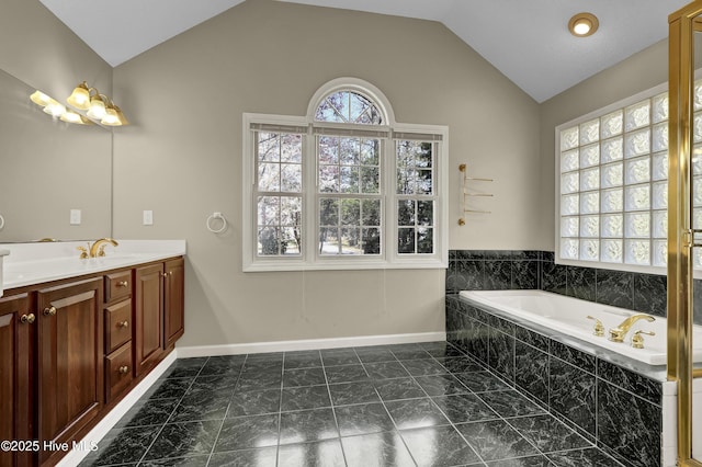 146 Olde Point Rd, Hampstead, NC 28443 - full bathroom featuring vaulted ceiling, double vanity, a garden tub, and marble look tiles