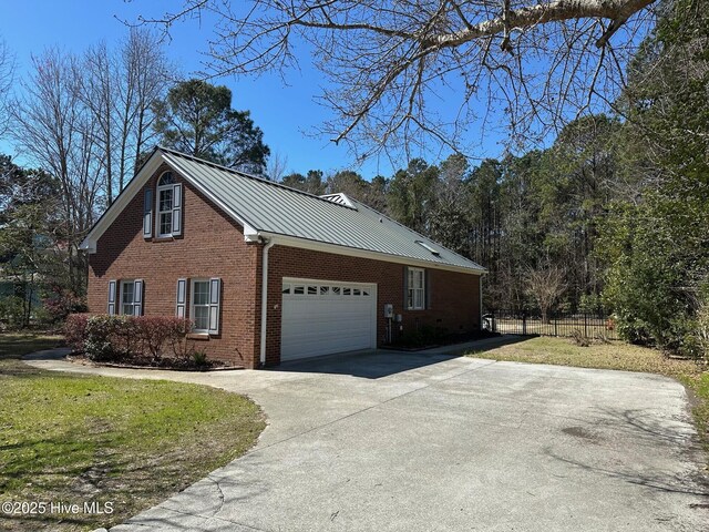 146 Olde Point Rd, Hampstead, NC 28443 - view of property exterior featuring driveway, brick siding, a metal roof, and an attached garage