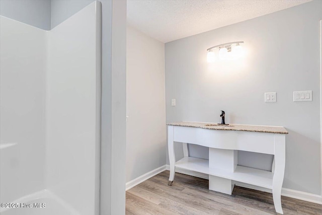 304 N Saratoga St, Stantonsburg, NC 27883 - bathroom with wood finished floors, baseboards, and a textured ceiling