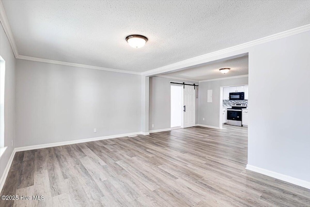 304 N Saratoga St, Stantonsburg, NC 27883 - unfurnished room featuring a barn door, a textured ceiling, light wood-style floors, baseboards, and ornamental molding