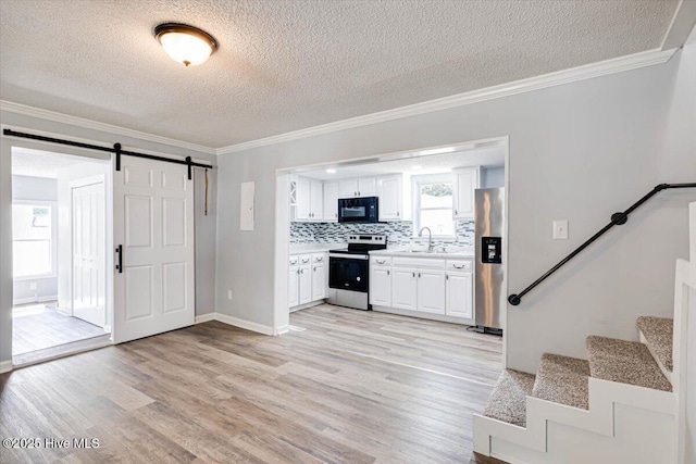 304 N Saratoga St, Stantonsburg, NC 27883 - kitchen featuring stainless steel appliances, a textured ceiling, a sink, light countertops, and crown molding