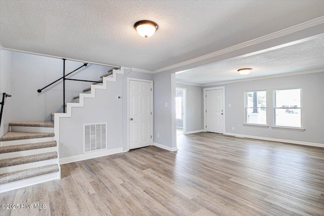 304 N Saratoga St, Stantonsburg, NC 27883 - unfurnished living room featuring a textured ceiling, stairs, wood finished floors, ornamental molding, and baseboards
