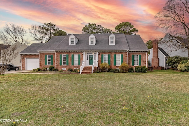 cape cod-style house with brick siding, a lawn, and a garage